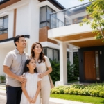Young Filipino family standing in front of a modern Breighton Land-inspired home